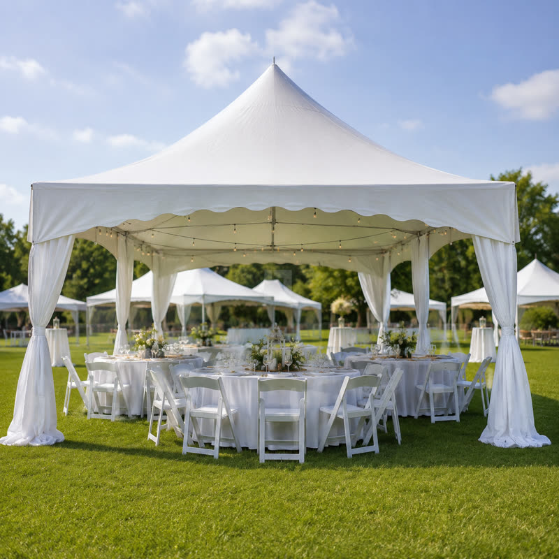 High-peak tent with draped legs set up over round tables and white folding chairs